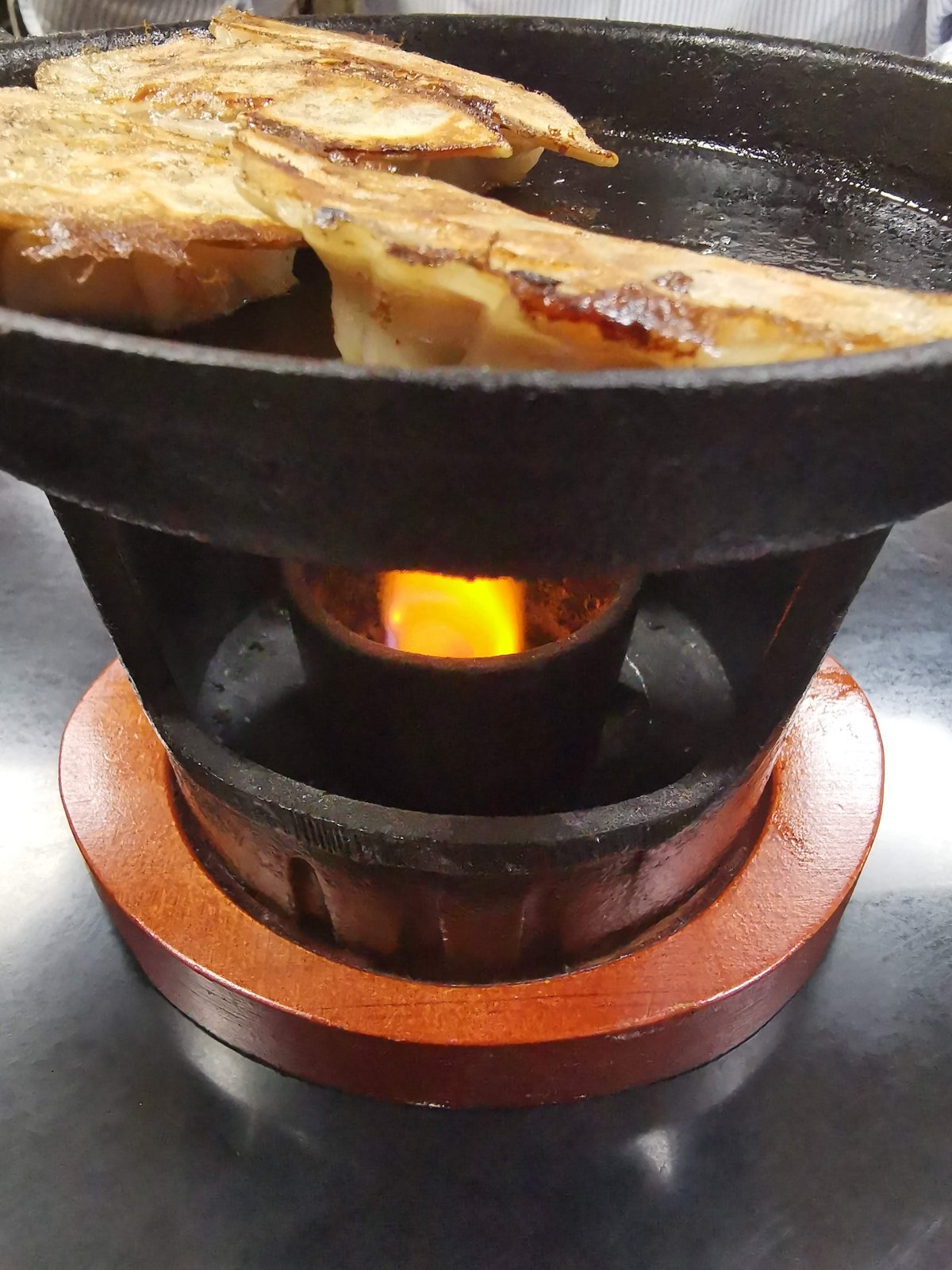 火にかけられた鉄鍋の餃子